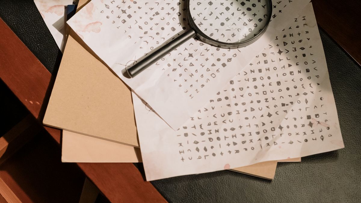 Lupa sobre hojas de papel con filas y filas de datos tabulados