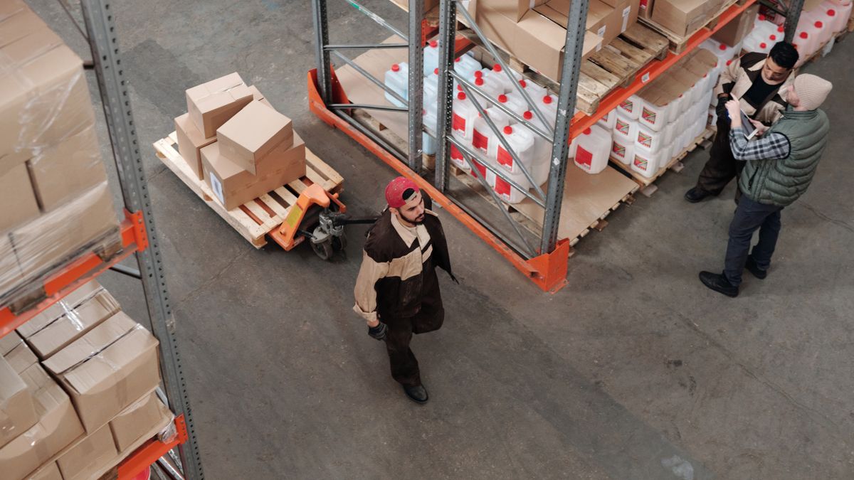 Operarios moviendo palés en el almacén de una empresa