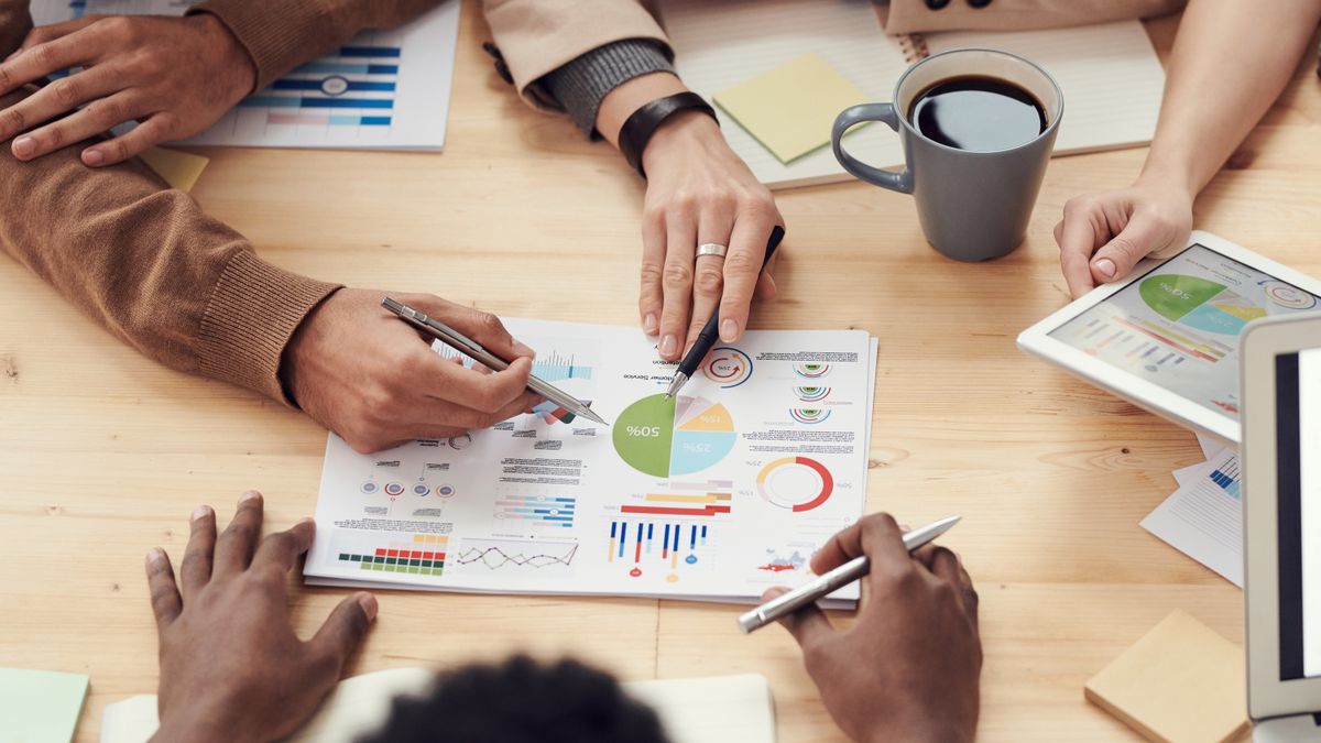 Equipo revisando gráficos e informes sobre una mesa de reuniones