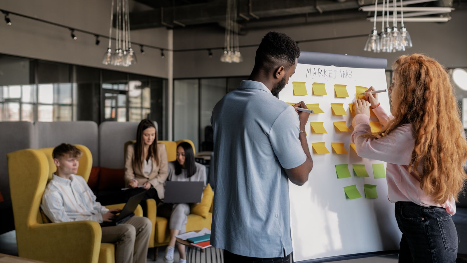 Equipo de marketing planificando una estrategia en una pizarra